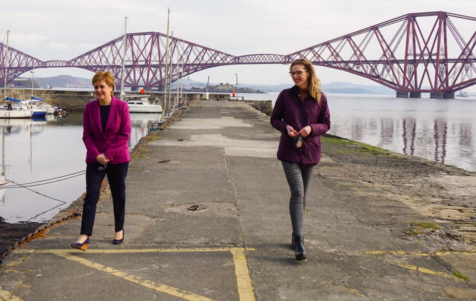 Nicola Sturgeon and Edinburgh Western Candidate Sarah Masson walking along the dock at South Queensferry with the Forth Bridge in the background